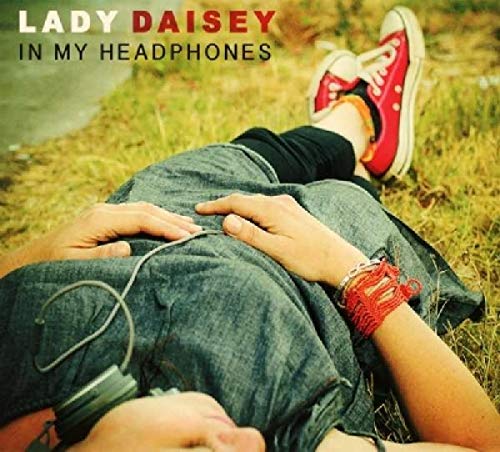 "Album cover: person lying on grass with headphones, wearing red sneakers."