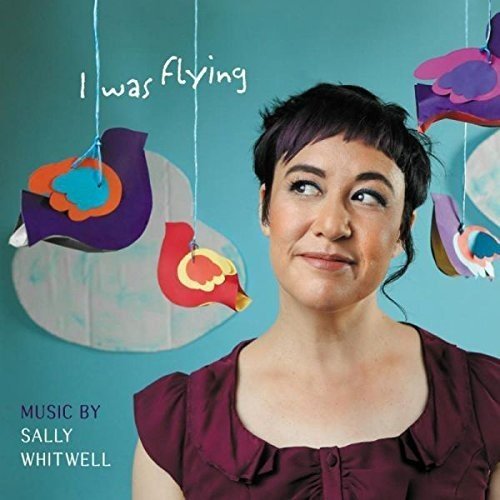 Woman in maroon top under colorful paper cutouts against teal background, album cover art.