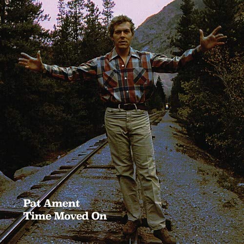 "Album cover with man standing on train tracks, arms outstretched, surrounded by trees."