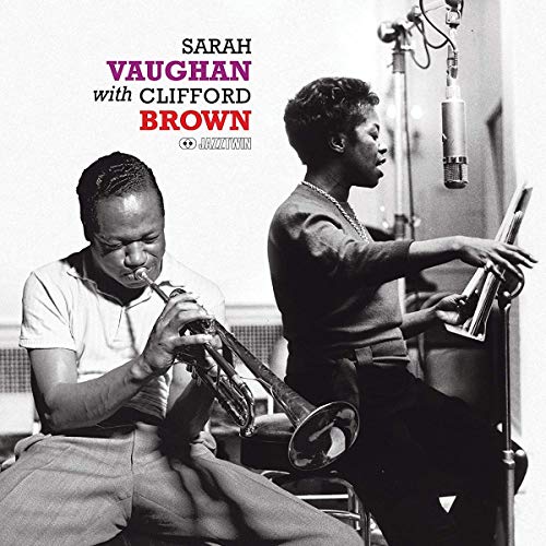 Clifford Brown playing trumpet while Sarah Vaughan sings into a microphone in a studio.