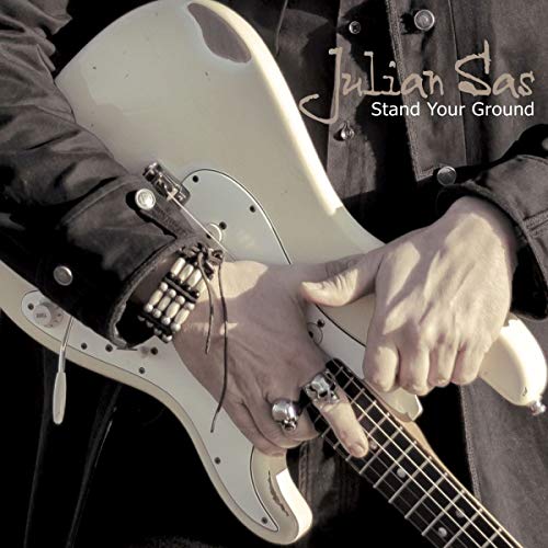 "Album cover featuring a person playing a white electric guitar, with artist and title."