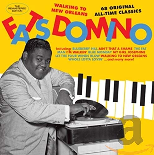 "Fats Domino CD cover with black and white photo of man at piano on yellow background."