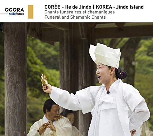 "CD cover featuring a shamanic figure in white robes holding a lit paper."