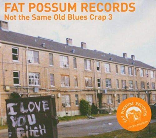 "Vinyl album cover showing a graffiti-covered dumpster in front of a rundown building."