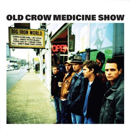 "CD cover featuring a group of men standing outside a building with a neon sign."