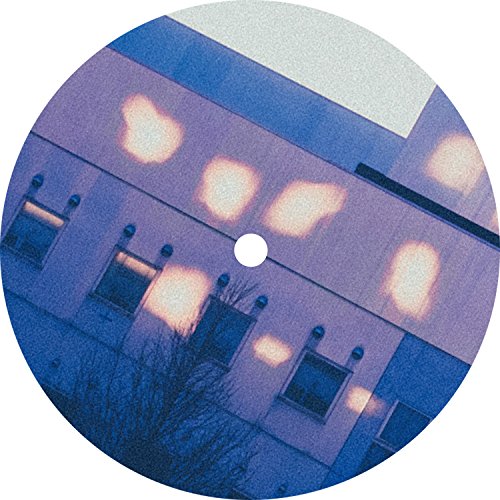Vinyl record with a blue-toned building image reflected on its surface.