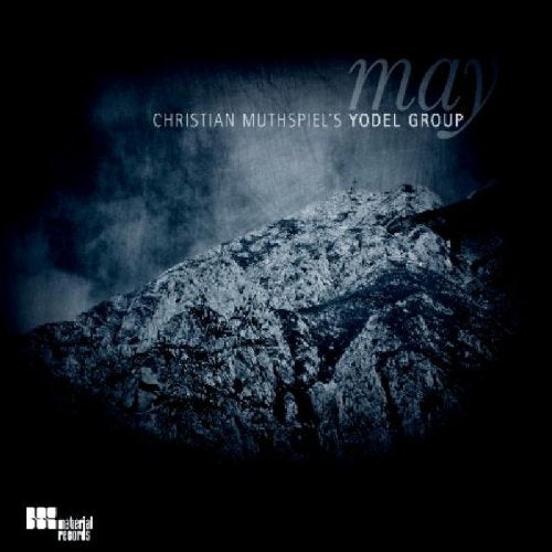 "CD cover with a dark, misty mountain landscape and 'may' written in cursive."