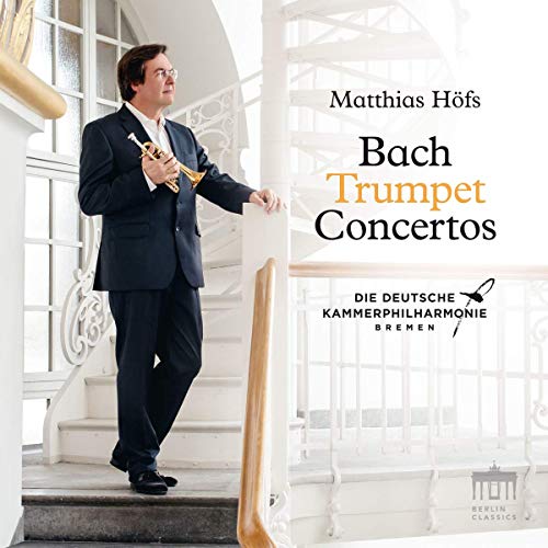 Man in black suit holding trumpet on staircase, CD cover for Bach Trumpet Concertos.