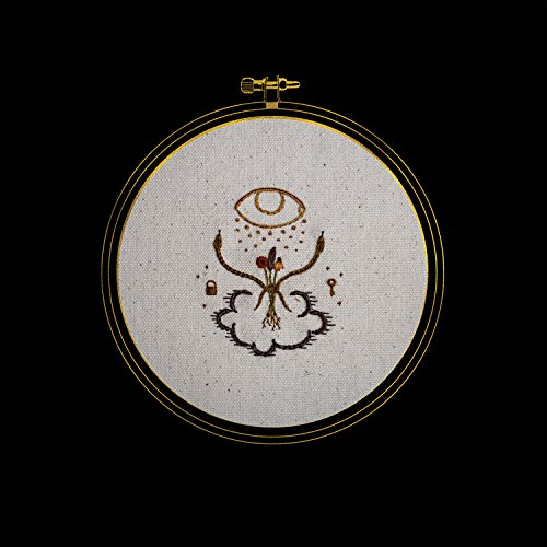The image shows a CD with a black background and embroidered artwork. For accessibility purposes, a concise alt text could be: "CD with embroidered artwork of an eye and roots."