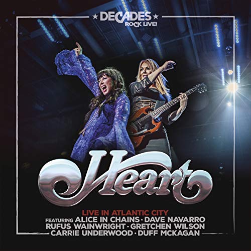 "Album cover featuring two women performing on stage with guitars and spotlights."