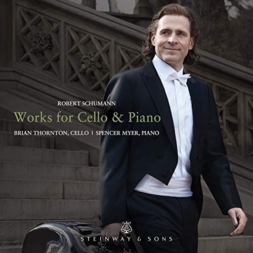 The image is a CD cover for Robert Schumann's "Works for Cello & Piano". The alt text is: Man in tuxedo holding cello case, with Steinway & Sons logo.