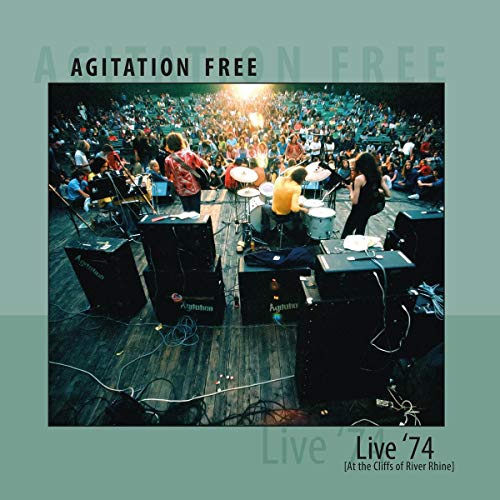 A vinyl record cover featuring a band performing on stage to a large audience.