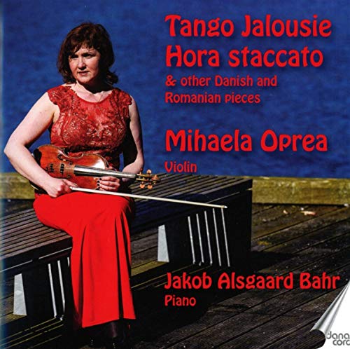"CD cover featuring a woman in red holding a violin on a dock."