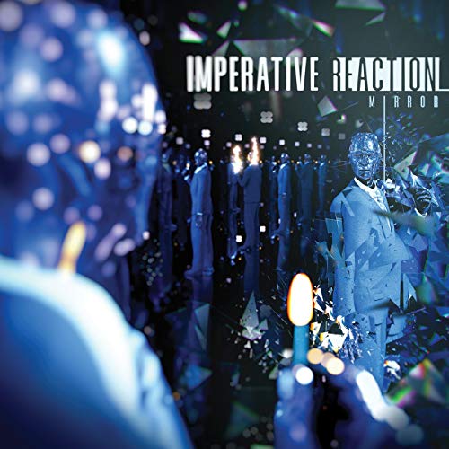 "Album cover featuring a man in a suit surrounded by shattered mirror reflections."