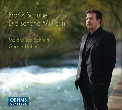 Man in a black suit stands beside a river on a CD cover.