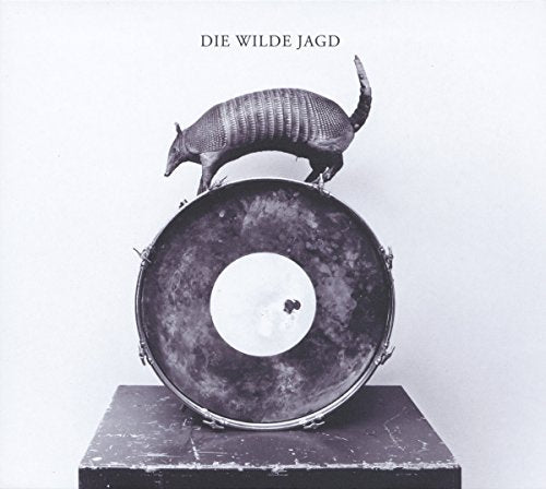 "Armadillo standing on a drum, album cover art, black and white image."