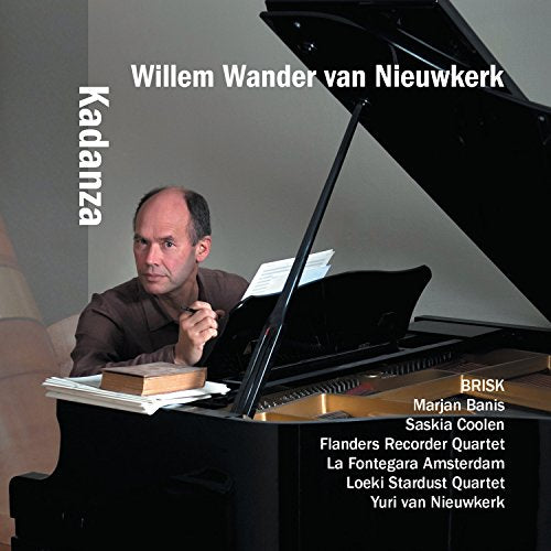 "Man sitting at a grand piano with sheet music and a book."