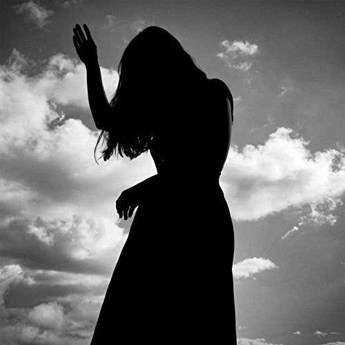 The image depicts a black-and-white album cover featuring a silhouette of a woman. Alt text: Silhouette of a woman against a cloudy sky on a CD album cover.