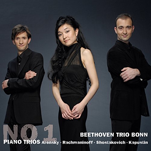 "CD cover featuring three musicians in black attire against a dark background."