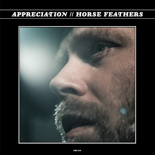 "Album cover with a close-up of a man's face on a black background."