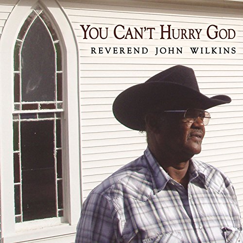 "CD cover with Reverend John Wilkins in front of a church, wearing a cowboy hat."