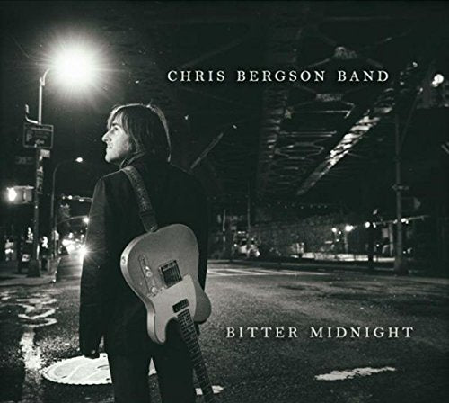 "Album cover: man with guitar standing on a wet street at night."