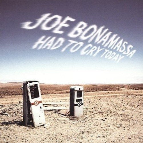 "CD album cover with desert scene and two broken gas pumps."