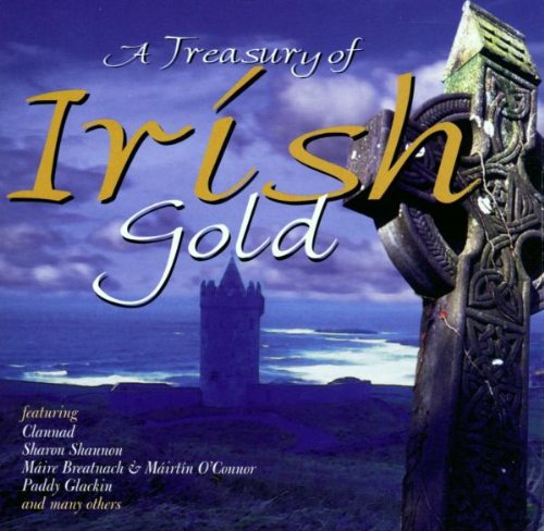 A Celtic cross stands in front of a medieval tower by the sea.