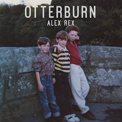 Vinyl record cover with three boys standing by a stone wall.