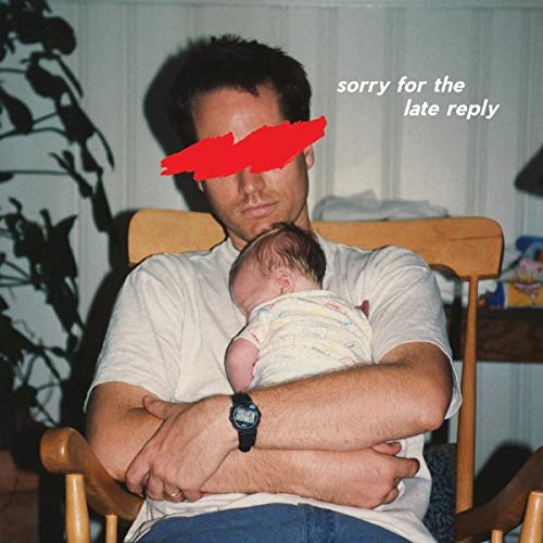 "Album cover with a man holding a baby, his face obscured by a red mark."