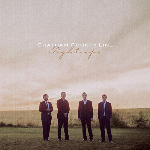 "Album cover featuring four men in suits standing in a field."
