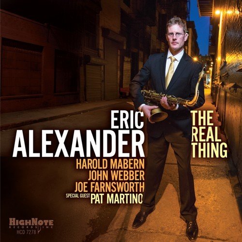 Album cover: man in suit holding saxophone on a city street at night.