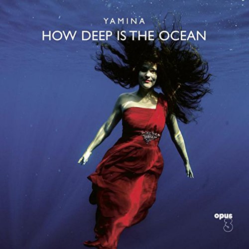 Album cover: woman in red dress underwater with flowing hair, against a blue background.