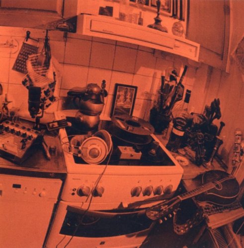 A cluttered kitchen counter with a guitar, microphone, and vinyl records, in a red tone.