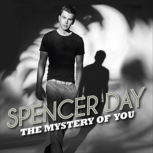 "Album cover with a man in a black t-shirt and shadowy figures behind."