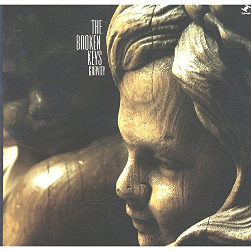 "CD album cover featuring a close-up of a bronze statue's face, titled 'Gravity'."