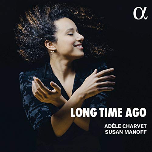 "Album cover with a woman in a black top, curly hair, and outstretched hands."