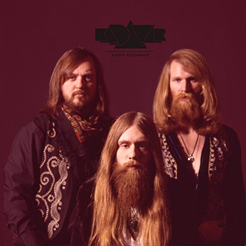 "Album cover featuring three men with long hair and beards against a dark red background."