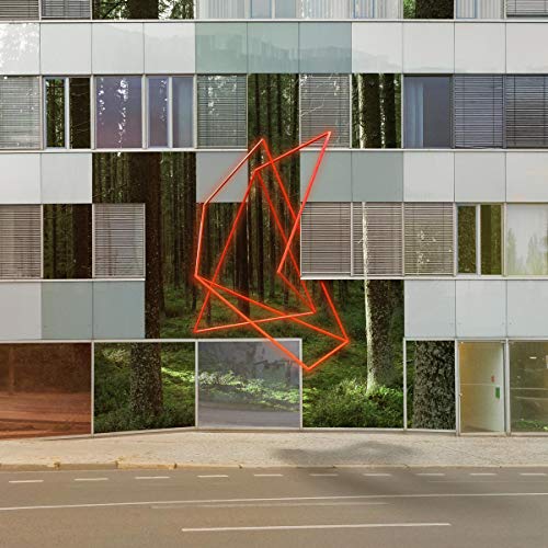 The image depicts a building facade with a red geometric shape. For accessibility purposes, a concise alt text could be: "A building with forest images and a red neon shape."