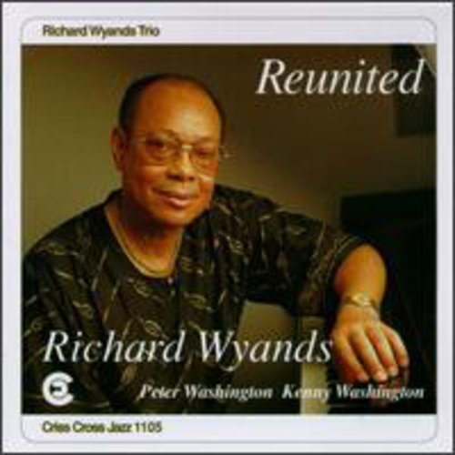 "Album cover featuring a man in a patterned shirt, smiling and leaning on a surface."
