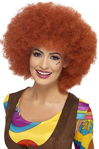 Woman wearing a large, curly auburn afro wig, colorful 1960s-style clothing, and green face dots.