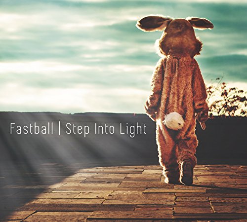 A child in a rabbit costume walks on a brick path with sunbeams.