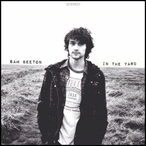 Black and white album cover with a man standing in a field.