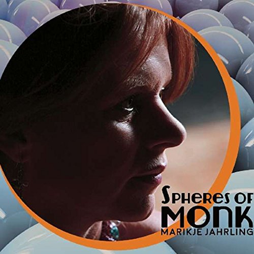 "Album cover with a woman's profile surrounded by blue spheres and orange circle."