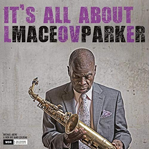 Maceo Parker holding a saxophone, wearing a suit, on a gray background.