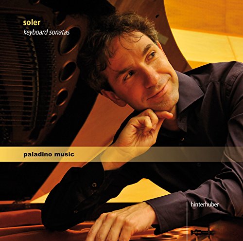 The image depicts a man resting his head on his hand, leaning on a piano. Alt text: Man leaning on a piano with a thoughtful expression.