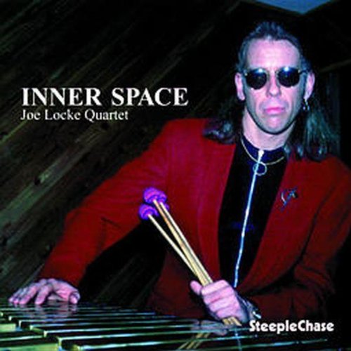 Album cover featuring a man playing a vibraphone, wearing a red jacket and sunglasses.