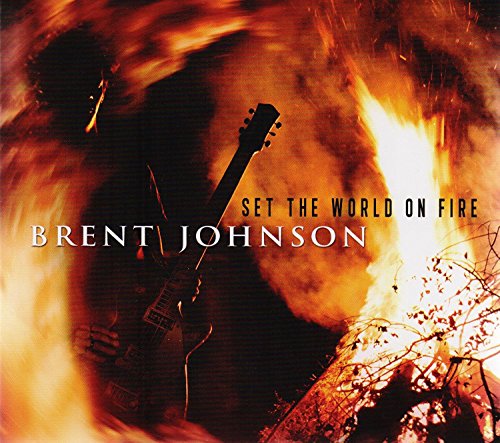 "Album cover with a silhouette of a man playing guitar amidst flames and smoke."