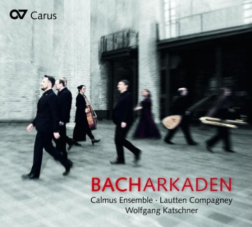 "CD cover with musicians walking, holding instruments, in black attire against a blurred background."