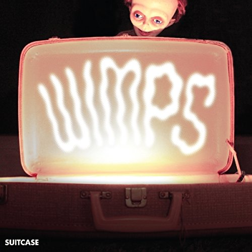 A doll peeks from a suitcase with "WIMPS" projected on the inside lid.